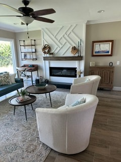 Coastal living room with geometric fireplace surround, swivel chairs, and ceiling fan