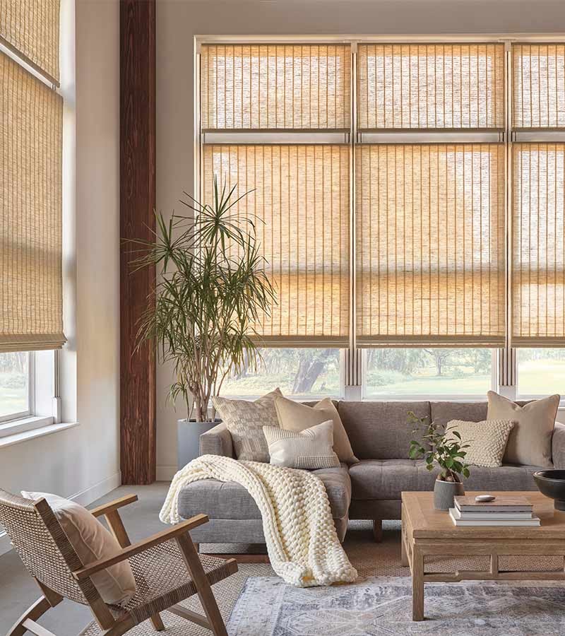 Boho chic woven wood shades in a warm neutral living room with natural textures